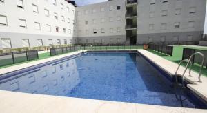 a large swimming pool in front of a building at ApartHome® in Bormujos