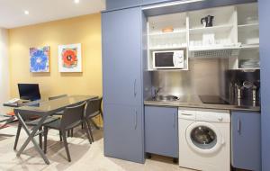 a kitchen and dining room with a table and a washing machine at ApartHome® in Bormujos