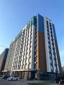 un gran edificio con coches estacionados en un estacionamiento en ЖК Ashyq Tobe, en Almaty