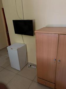 um quarto com um pequeno frigorífico e uma televisão na parede em SUPERSTONE LODGE em Lusaka