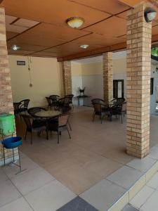 un patio avec des tables et des chaises dans un bâtiment dans l'établissement SUPERSTONE LODGE, à Lusaka