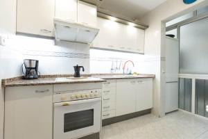 eine Küche mit weißen Schränken und einem Waschbecken in der Unterkunft David's House in Barcelona