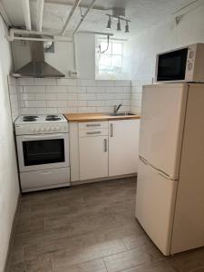 eine Küche mit weißen Geräten und einem weißen Kühlschrank in der Unterkunft The Yellow House in Malmö