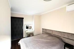 1 dormitorio con cama y cabecero negro en Cosy T2 at 10 minutes from the sea!, en Mandelieu-la-Napoule