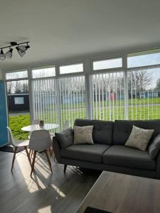 a living room with a couch and a table at Chalet in Stalham in Stalham