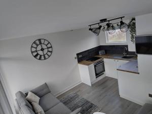 a living room with a couch and a kitchen at Chalet in Stalham in Stalham
