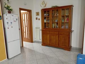 a kitchen with a refrigerator and a wooden cabinet at B&B I Tre Ulivi in Morro dʼOro