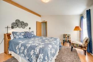 Un dormitorio con una cama azul y blanca y una silla en Idyllic Rock Island Home with Columbia River Views 