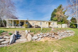 a house with a stone wall in front of a yard at Idyllic Rock Island Home with Columbia River Views 