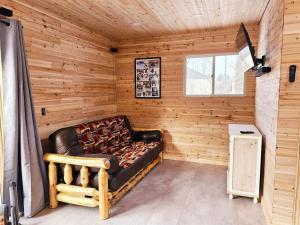 Habitación con sofá de cuero en una habitación de madera en Close to Munising, Pictured Rocks, ORV access, en Shingleton