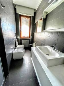 a bathroom with a sink and a tub and a toilet at -Penthouse con Terrazza Panoramica -Free Parking- in Carrara