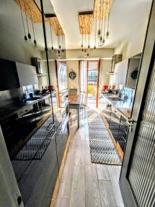 a kitchen with wooden floors and glass walls at -Penthouse con Terrazza Panoramica -Free Parking- in Carrara