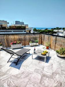 a patio with a table and chairs and a fence at -Penthouse con Terrazza Panoramica -Free Parking- in Carrara
