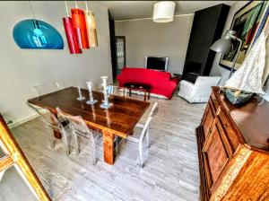 a living room with a wooden table and a red couch at -Penthouse con Terrazza Panoramica -Free Parking- in Carrara