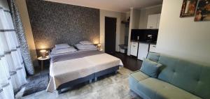 a bedroom with a bed and a couch at Holiday House Berekfürdő in Berekfürdő