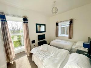 a bedroom with two beds and a window at Clydfan in Holyhead