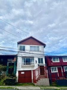 una casa roja y blanca con garaje rojo en Hospedaje Familiar Glady's House, en Puerto Montt