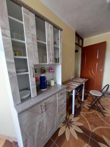 een keuken met witte kasten en een tafel in een kamer bij Disha's Home Casa Hospedaje in Ayacucho