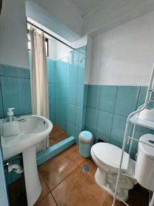 a blue bathroom with a sink and a toilet at Disha's Home Casa Hospedaje in Ayacucho