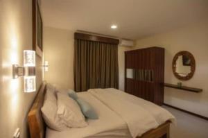 1 dormitorio con cama y espejo en la pared en Dawn Golf Villa, en Tanjung