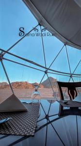 a chair under an umbrella with a laptop on it at Sama Wadi Rum in Wadi Rum