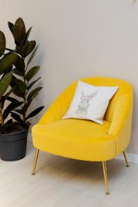 a yellow chair with a pillow on top of it at RestArt Boutique Hotel in Dilijan