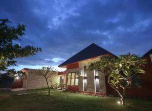 una casa con un patio con árboles delante de ella en Dawn Golf Villa, en Tanjung