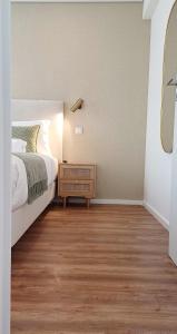 een slaapkamer met een groot bed en een houten vloer bij Douro View Charming Apartment Duplex in Valbom