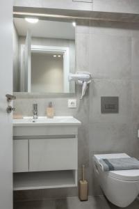 une salle de bains avec lavabo, toilettes et miroir dans l'établissement Monastiraki Urban Studio, à Athènes 75 autres photos