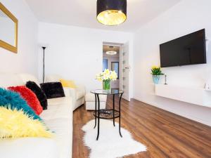 クラクフにあるApartament Kolorowyの白いソファとテーブルのあるリビングルーム