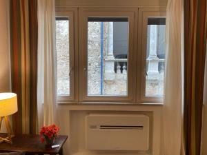 a living room with two windows and a heater at Loggiato Palazzo San Matteo in Palermo