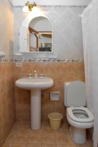 uma casa de banho com um lavatório, um WC e um espelho. em Rincon de Sueños em Tilcara