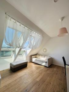 uma sala de estar no sótão com 2 camas e janelas grandes em Double Floor Apartment em Viena