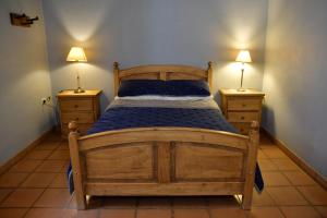 ein Schlafzimmer mit einem Holzbett mit zwei Nachttischen in der Unterkunft Rincon de Sueños in Tilcara