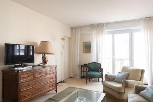 a living room with a tv on a dresser at Lovely 66 m 2 steps from the city center in Boulogne-Billancourt
