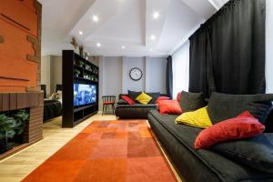 uma sala de estar com um sofá e uma televisão em DaugavaLuxApartments Free Parking em Riga