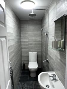 a bathroom with a toilet and a sink at Entire 6 bedroom house in Oldham in Moston