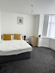 um quarto branco com uma cama e uma janela em Entire 6 bedroom house in Oldham em Moston