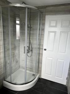 y baño con ducha y puerta de cristal. en Entire 6 bedroom house in Oldham en Moston
