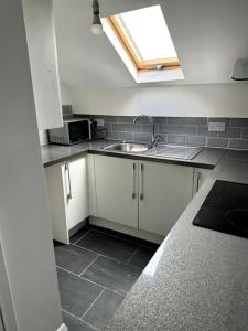 een kleine keuken met een wastafel en een raam bij Entire 6 bedroom house in Oldham in Moston