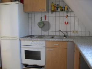 uma cozinha com um fogão branco e um lavatório em Ferienwohnung in Volksdorf mit Großer Terrasse em Meerbeck