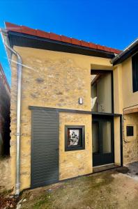 a building with a garage door with a picture on it at Les Gites d'Andréa- Chez les Fifou in Surba +17 photos
