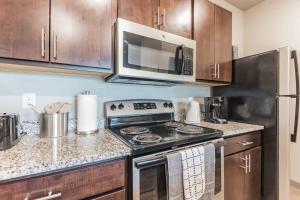 een keuken met een fornuis en een magnetron bij Spacious 2BR Suite Plus Patio Near Iowa State in Ames