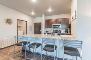a kitchen with a counter and stools at a bar at Spacious 2BR Suite Plus Patio Near Iowa State in Ames