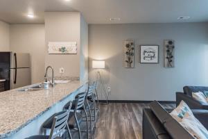 een keuken met een aanrecht met stoelen en een koelkast bij Spacious 2BR Suite Plus Patio Near Iowa State in Ames +24 foto's