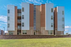 a tall building with a grass field in front of it at Spacious 2BR Suite Plus Patio Near Iowa State in Ames