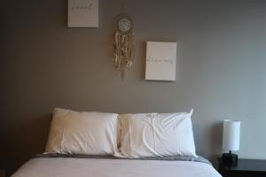 uma cama com almofadas brancas e um relógio na parede em Spacious 2BR Suite Plus Patio Near Iowa State em Ames