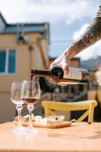 a person pouring wine into two glasses on a table at RestArt Boutique Hotel in Dilijan