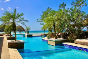 uma piscina com palmeiras e praia em Steps From Ocean Couple's Getaway Private Villa em Playa Venao