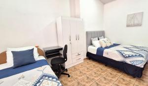 a bedroom with two beds and a cabinet and a desk at Oceanic Playa Matapalo in Matapalo
